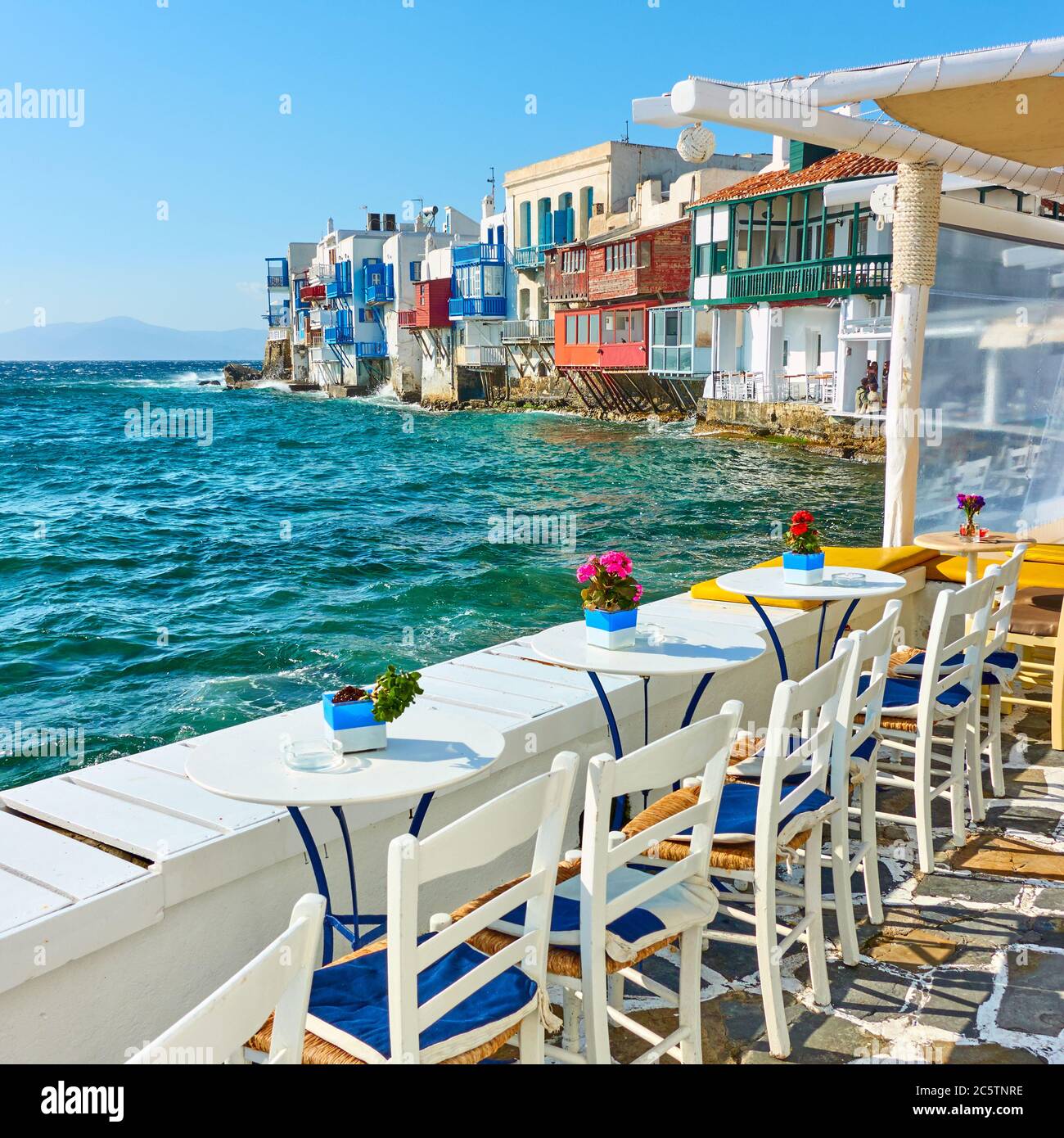 Café en plein air près de célèbres maisons au bord de la mer, sur l'île de Mykonos, en Grèce Banque D'Images