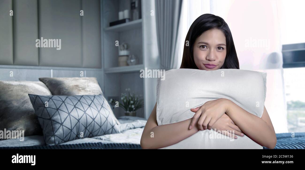 une bonne fille asiatique oreiller sur un lit confortable à la maison Banque D'Images