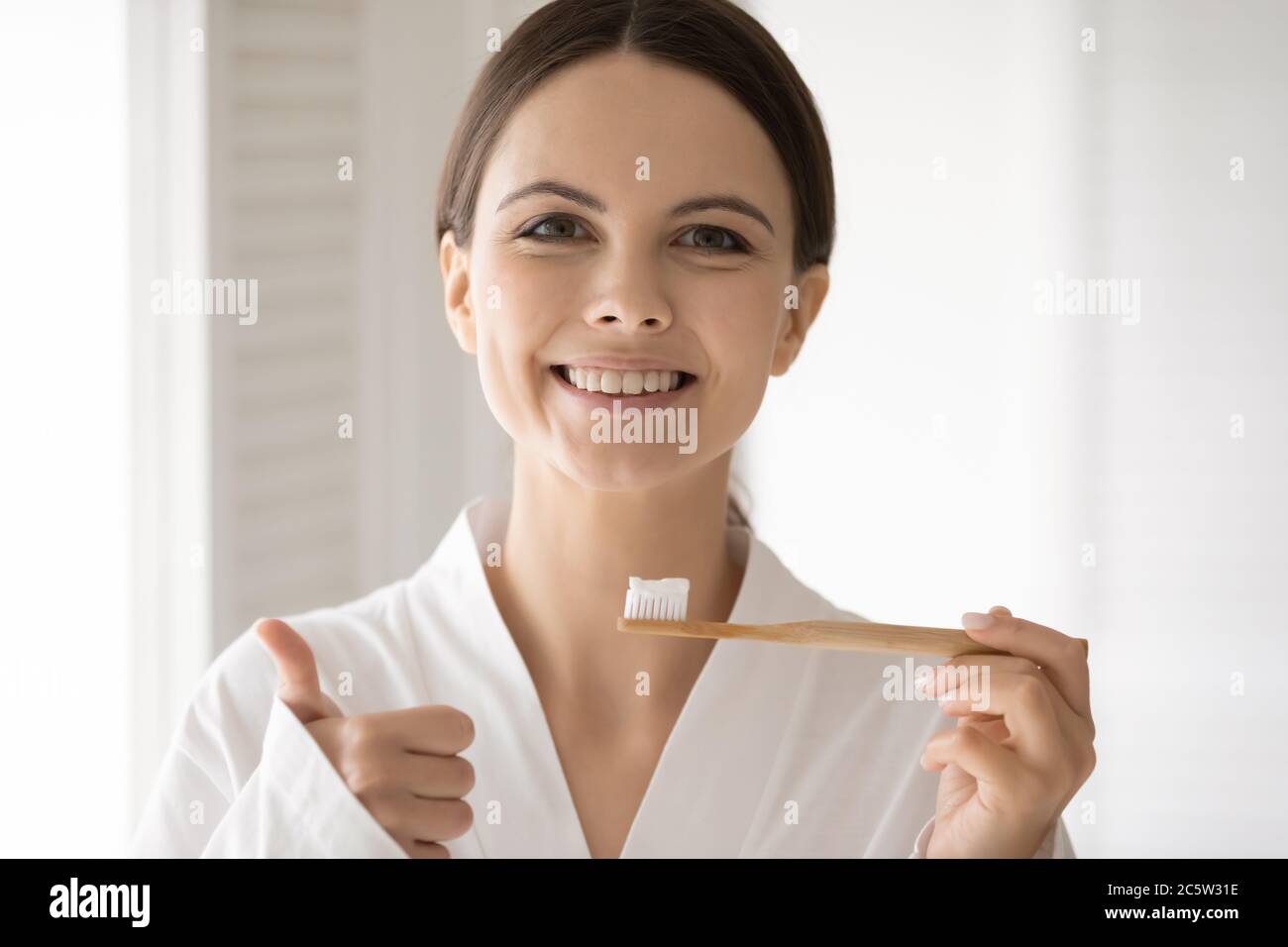 Portrait de tête souriante femme tenant recommandant une brosse à dents écologique Banque D'Images