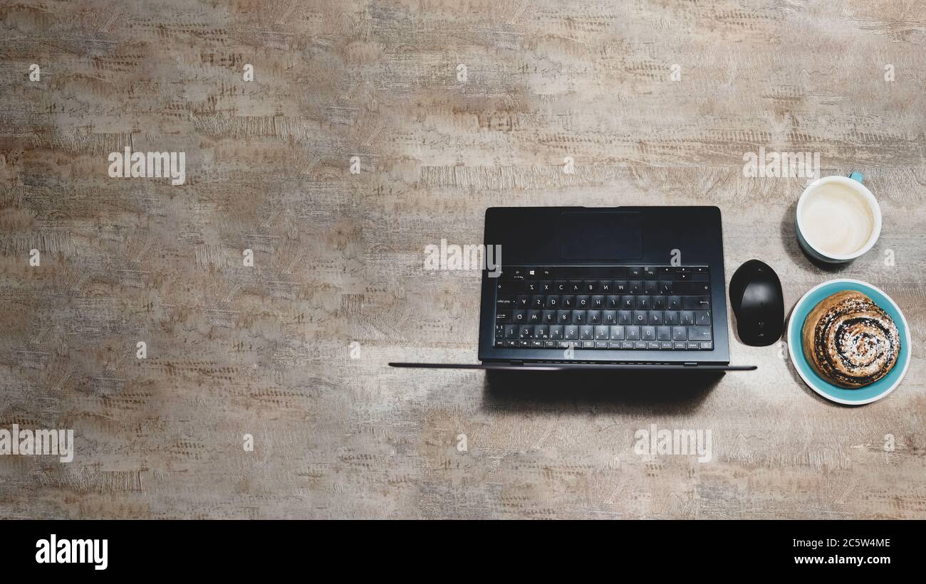 Disposition plate de la table avec ordinateur portable, souris d'ordinateur, tasse de café et pain de graines de pavot sur une surface en bois, Banque D'Images