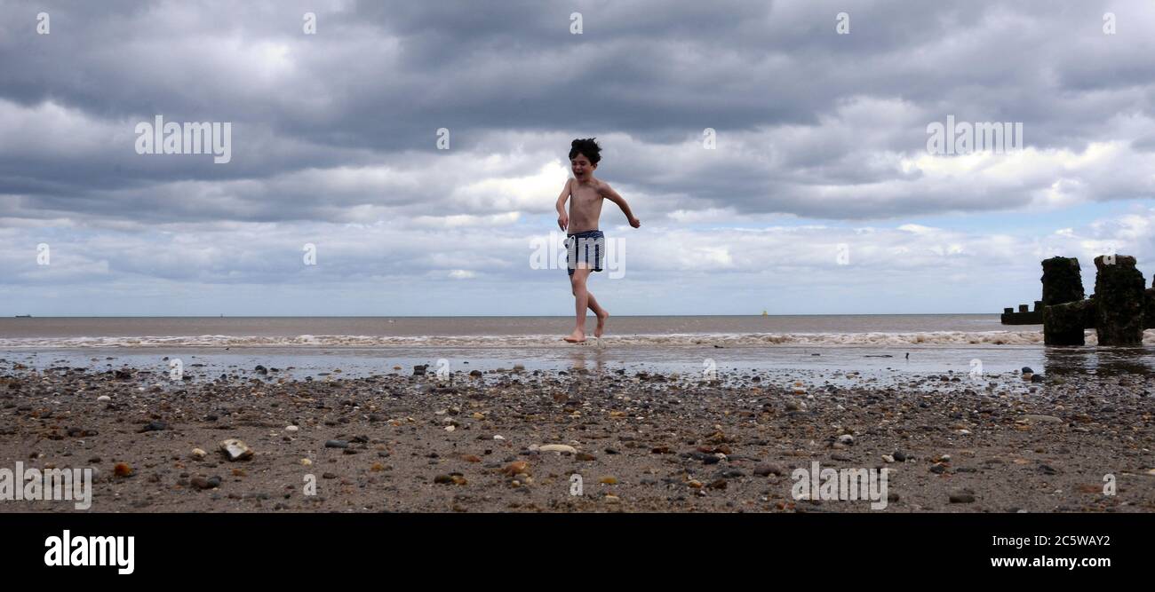Garçon jouant dans la mer, Hornsea, Banque D'Images