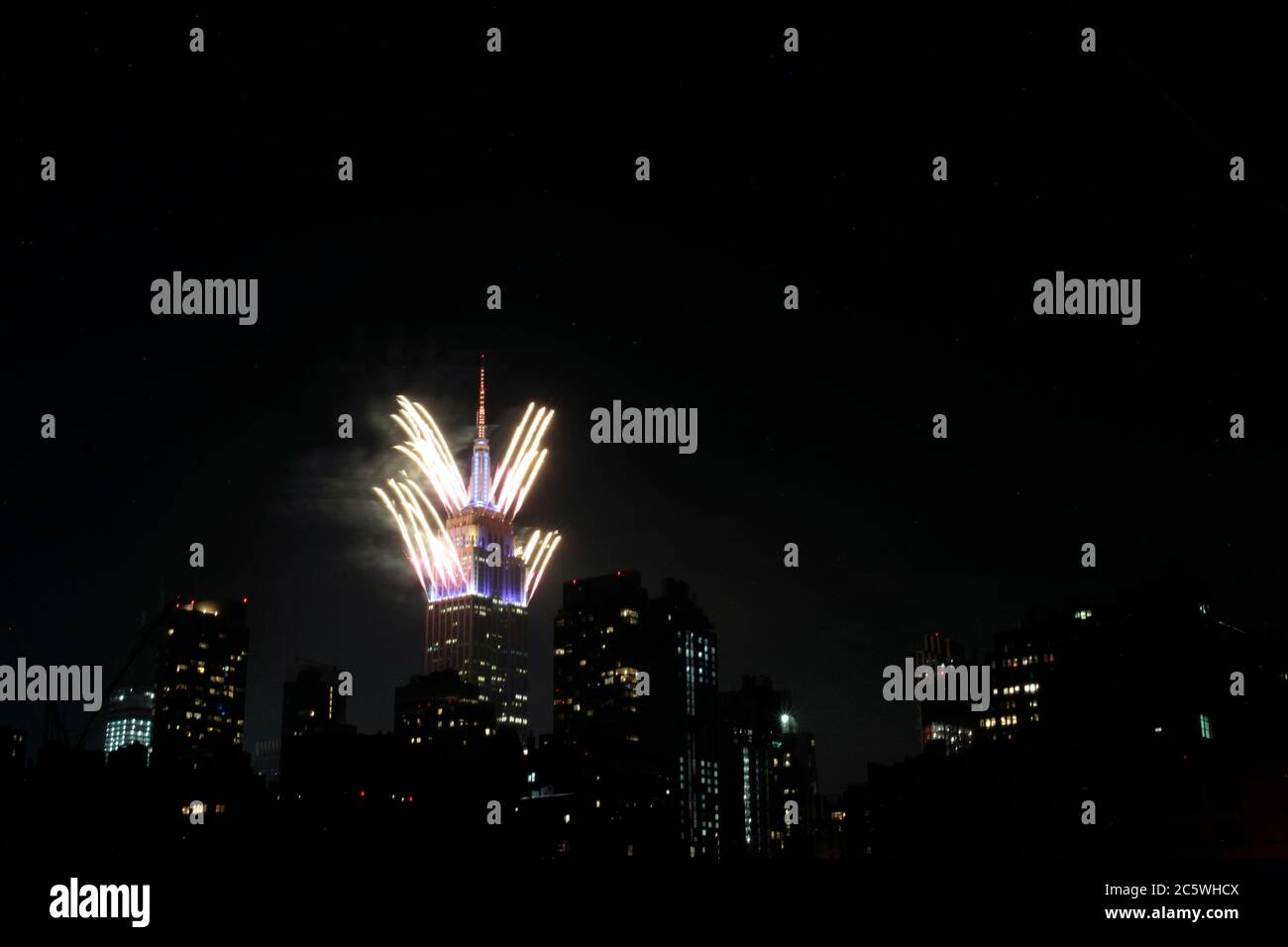 New York, New York, États-Unis. 4 juillet 2020. Des feux d'artifice sont lancés depuis le sommet de l'Empire State Building à New York le samedi soir, dans ce qui a été une célébration très discrète dans la plupart des États-Unis du 4 juillet, la Journée de l'indépendance américaine. Le moment et l'emplacement des feux d'artifice à New York n'ont pas été annoncés à l'avance afin d'empêcher la formation de foules pour les voir, étant donné la pandémie du coronavirus et la crise de santé publique qui existe encore. Crédit : Adam Stoltman/Alamy Live News Banque D'Images