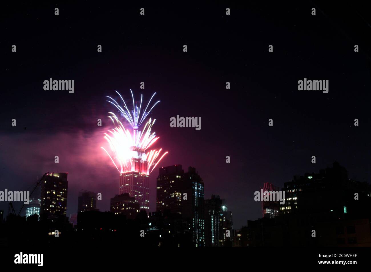 New York, New York, États-Unis. 4 juillet 2020. Des feux d'artifice sont lancés depuis le sommet de l'Empire State Building à New York le samedi soir, dans ce qui a été une célébration très discrète dans la plupart des États-Unis du 4 juillet, la Journée de l'indépendance américaine. Le moment et l'emplacement des feux d'artifice à New York n'ont pas été annoncés à l'avance afin d'empêcher la formation de foules pour les voir, étant donné la pandémie du coronavirus et la crise de santé publique qui existe encore. Crédit : Adam Stoltman/Alamy Live News Banque D'Images