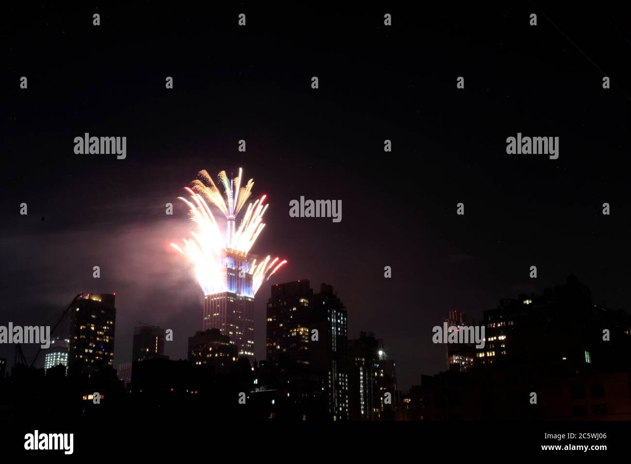 New York, New York, États-Unis. 4 juillet 2020. Des feux d'artifice sont lancés depuis le sommet de l'Empire State Building à New York le samedi soir, dans ce qui a été une célébration très discrète dans la plupart des États-Unis du 4 juillet, la Journée de l'indépendance américaine. Le moment et l'emplacement des feux d'artifice à New York n'ont pas été annoncés à l'avance afin d'empêcher la formation de foules pour les voir, étant donné la pandémie du coronavirus et la crise de santé publique qui existe encore. Crédit : Adam Stoltman/Alamy Live News Banque D'Images