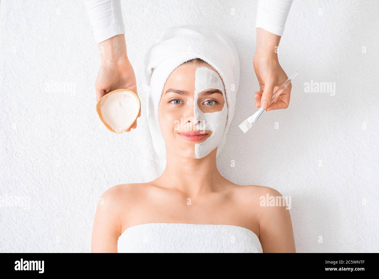 Femme avec masque sur la moitié de son visage sur blanc Banque D'Images