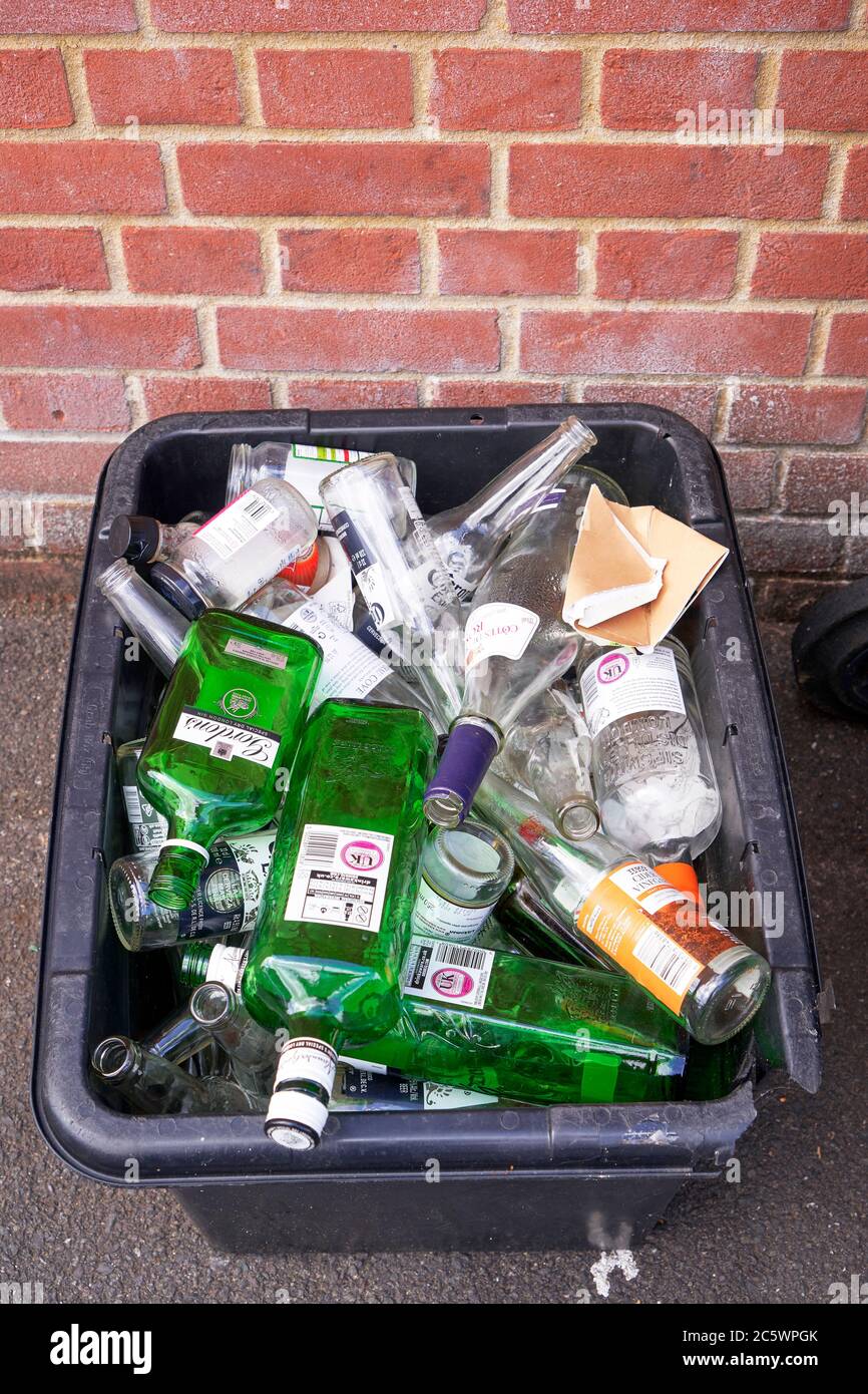 Vider les bouteilles en verre pour recyclage dans une boîte noire Banque D'Images