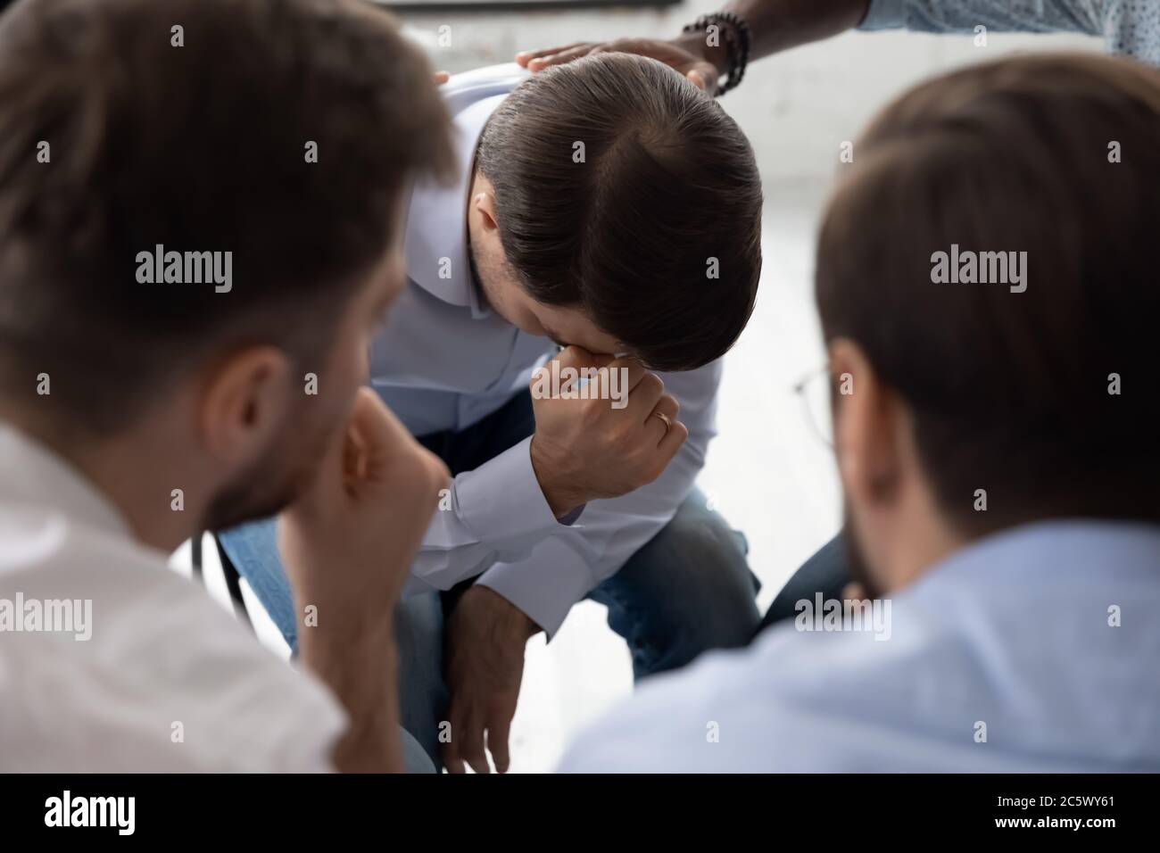 Les gens expriment de l'empathie à un gars désespéré pendant la séance de thérapie Banque D'Images