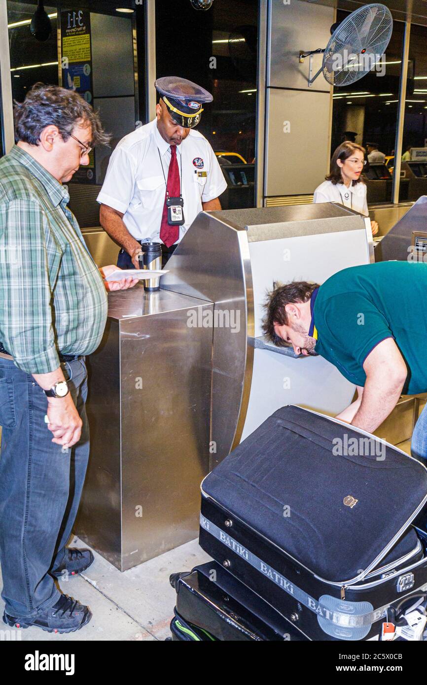 Miami Florida International Airport MIA,EGS,Executive Ground Services,Skycap,sous-traitant,Black man men male adulte, en bordure du trottoir,enregistrement,bagages,s Banque D'Images