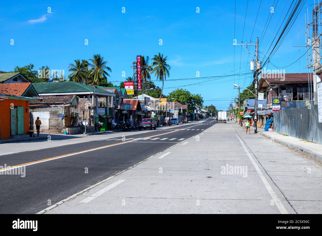 Dumaguete, Philippines - 07 avril 2020 : autoroute vide du village philippin pendant la quarantaine du coronavirus. Style de vie philippin moderne. Magasins et Banque D'Images
