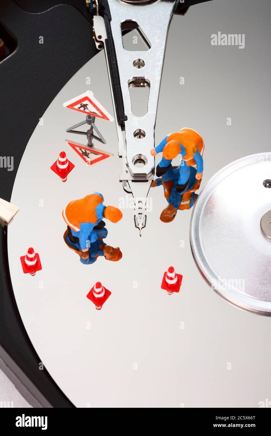 Ordinateur PC diorama avec des ouvriers miniatures inspectant la surface d'un disque dur de données à la recherche d'erreurs Banque D'Images