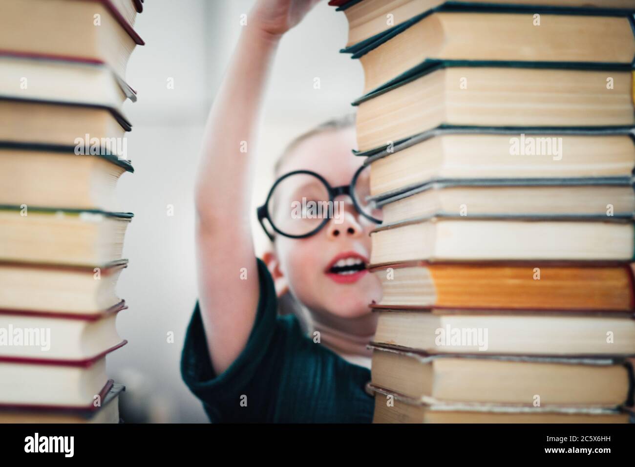 Le génie de petite fille d'âge préscolaire lit une tonne de livres.  Éducation des enfants et développement précoce concept Photo Stock - Alamy