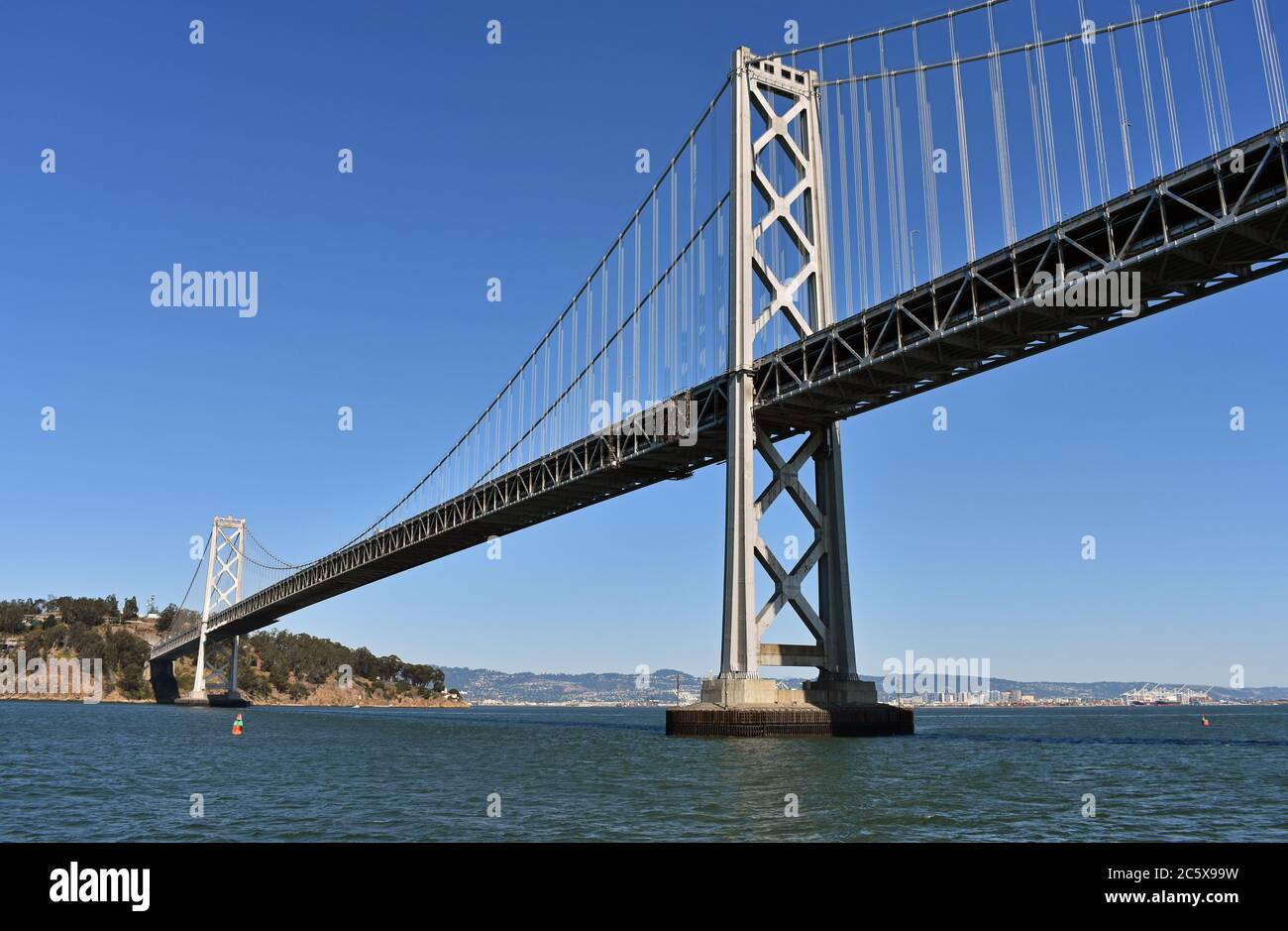 De San Francisco à Oakland Bay Bridge et Treasure Island. Horizon d'Oakland City au loin derrière le pont suspendu gris. Californie. Banque D'Images