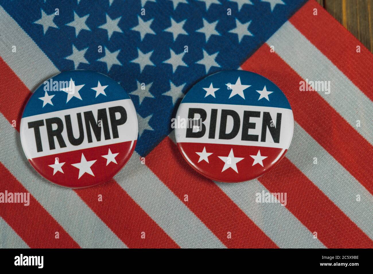 Washington DC--5 juillet 2020 ; les boutons de campagne présidentielle rouges, blancs et bleus, Donald Trump et Joe Biden sont placés sur un drapeau américain, sur une patte en bois Banque D'Images