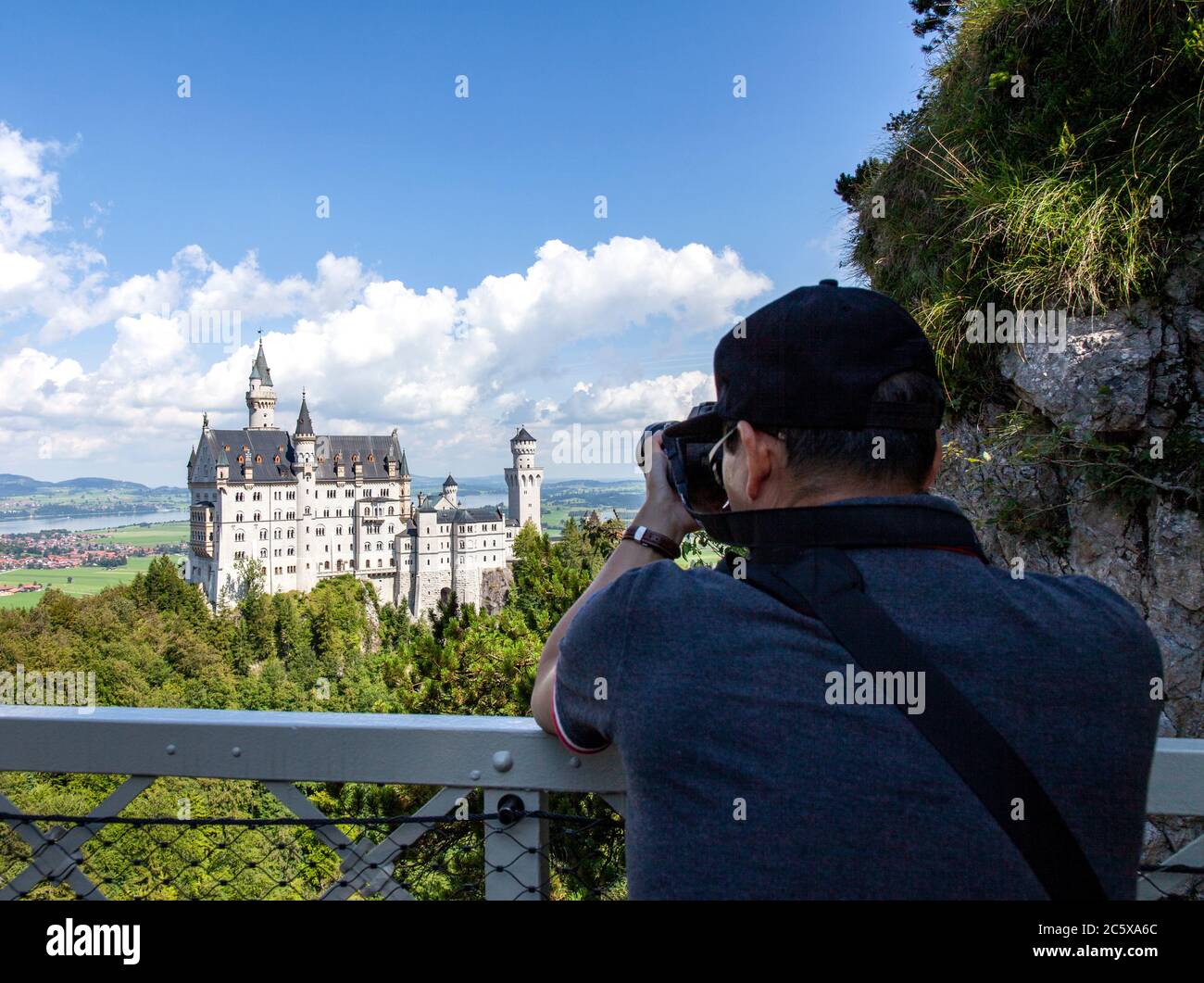 Un touriste veut son objectif au château de Neuschwanstein. Ce palais roman du XIXe siècle se trouve sur une colline escarpée au-dessus du village de Hohenschwa Banque D'Images