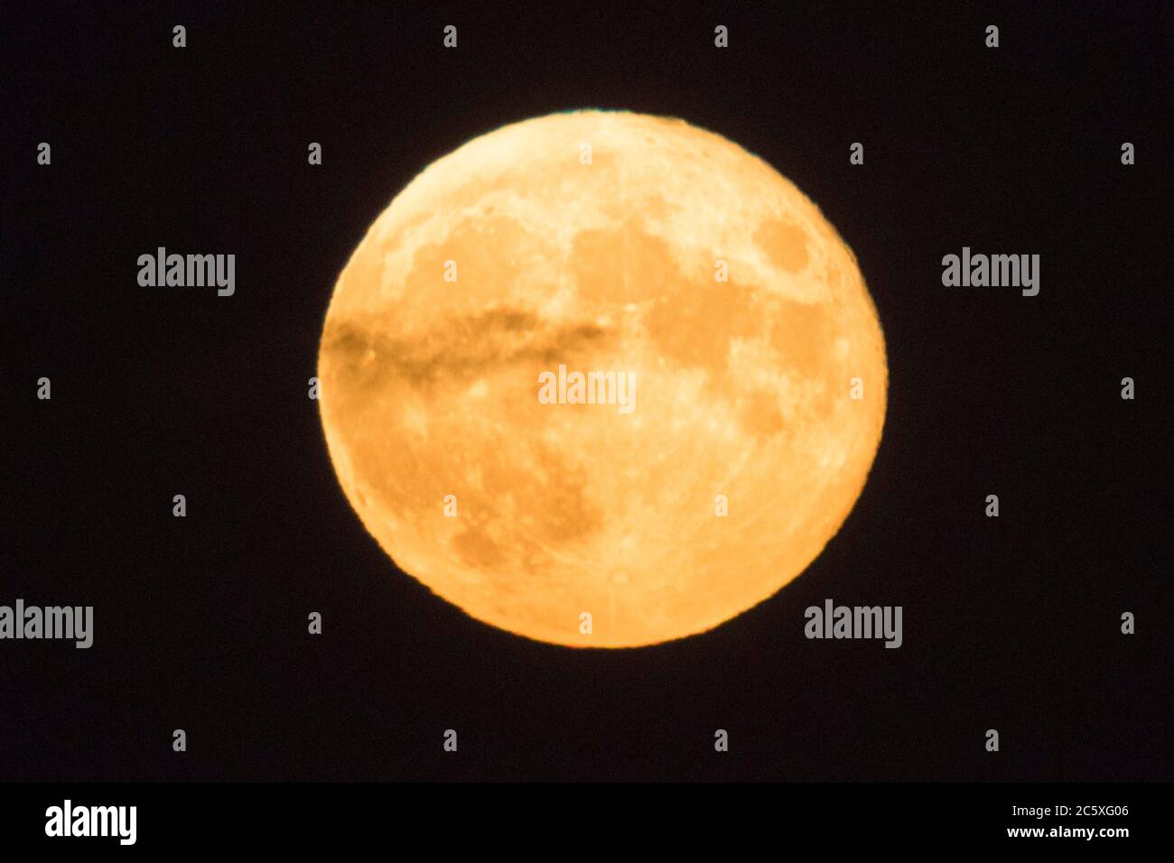 Highcliffe, Dorset, Royaume-Uni. 5 juillet 2020. Météo Royaume-Uni. La pleine Buck Moon brille d'orange alors qu'un nuage de wispy passe devant lui, vu de Highcliffe dans Dorset peu après la lune. Crédit photo : Graham Hunt/Alay Live News Banque D'Images