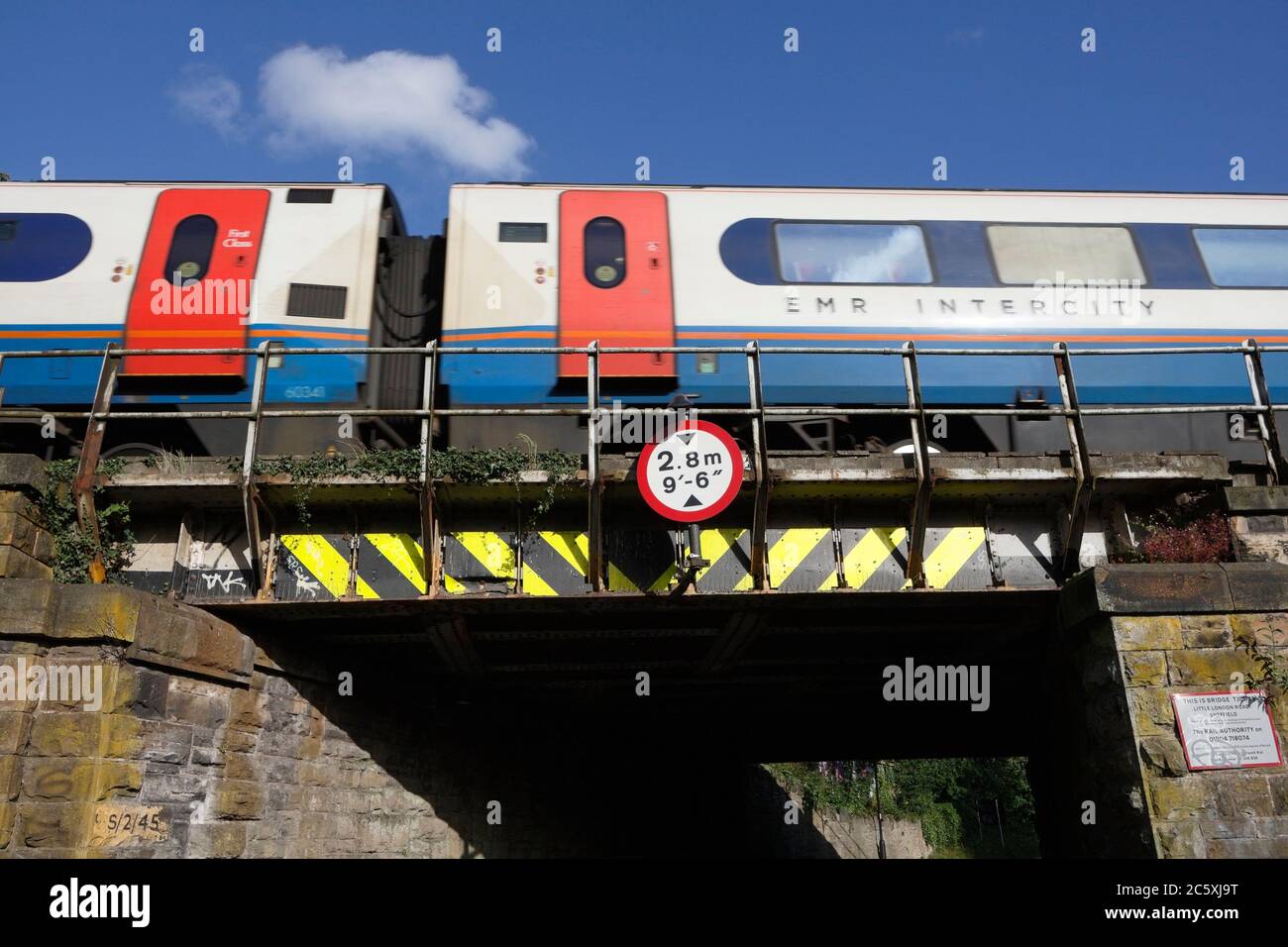 Pont ferroviaire bas, à Abbeydale Sheffield Angleterre train de passagers, panneau de hauteur du pont Banque D'Images