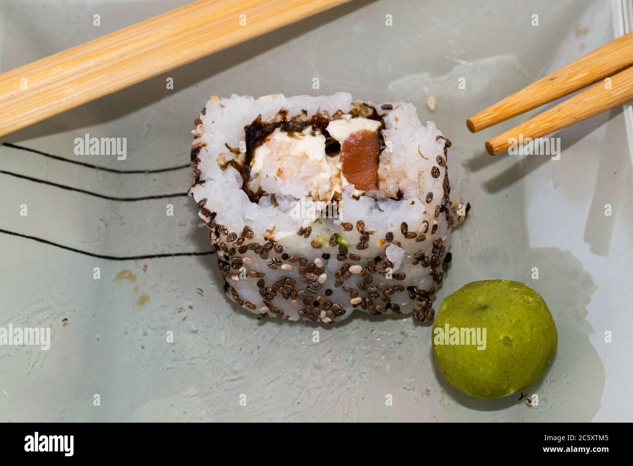 Les sushis japonais sont excellents. Maki et petits pains au thon, au saumon et à l'avocat. Vue de dessus du rouleau de sushi. wasabi. Foyer sélectif. Banque D'Images