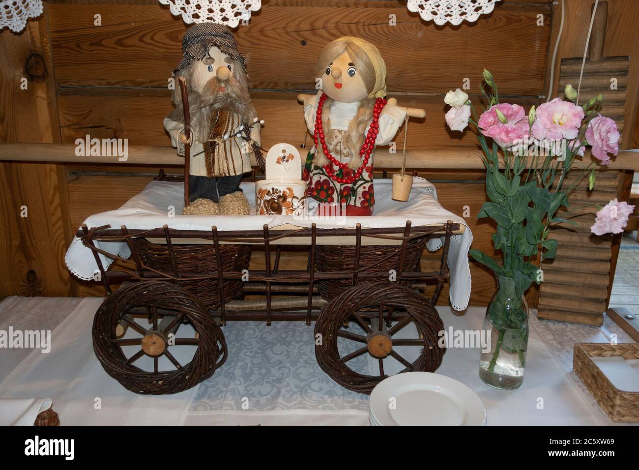 Décoration de charrette avec poupées homme et femme à l'entrée accueillant les gens au restaurant Karczma Spalska. Spala Pologne centrale Banque D'Images