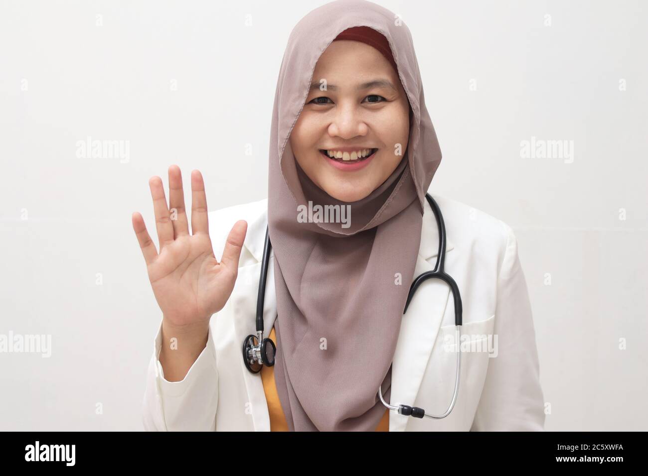 Belle jeune asiatique musulmane femme médecin femme utilisant le stéthoscope sur fond blanc isolé. En vous saluant, vous êtes heureux et souriant, et c'est sympa Banque D'Images