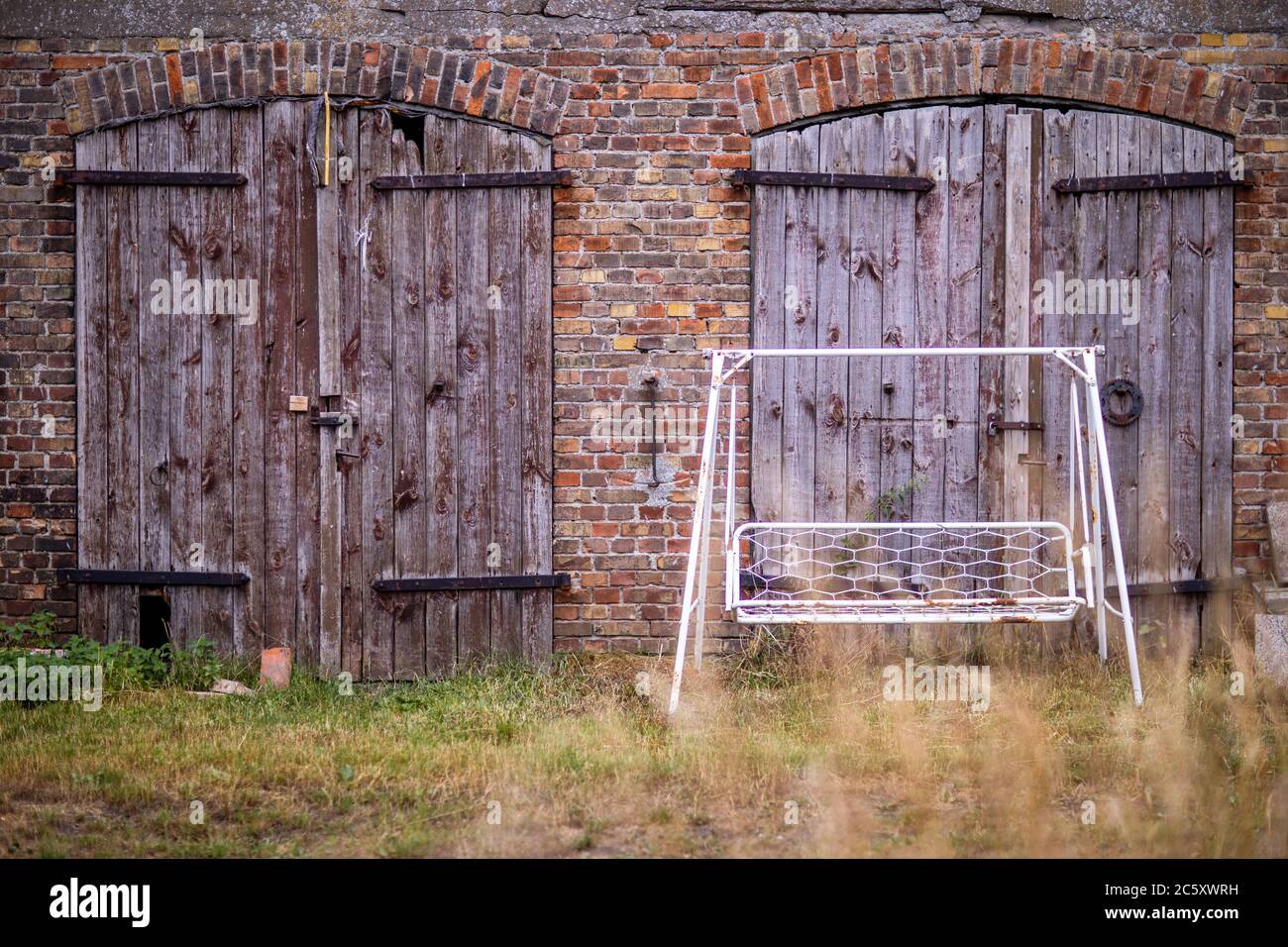 Greifswald, Allemagne. 02 juillet 2020. Une vieille balançoire hollywoodienne se trouve en face d'un ancien bâtiment agricole sur l'île de la réserve naturelle de Koos. Après la renaturation, les espèces animales et végétales qui auraient été perdues sont de retour ces dernières années. La Fondation Succow a été créée en 1999 comme première fondation à but non lucratif pour la conservation de la nature dans les nouveaux États allemands. En 2016, il a pris plus de 365 hectares sur l'île et dans les prés de Karrendorf sur le continent. Credit: Jens Büttner/dpa/Alay Live News Banque D'Images