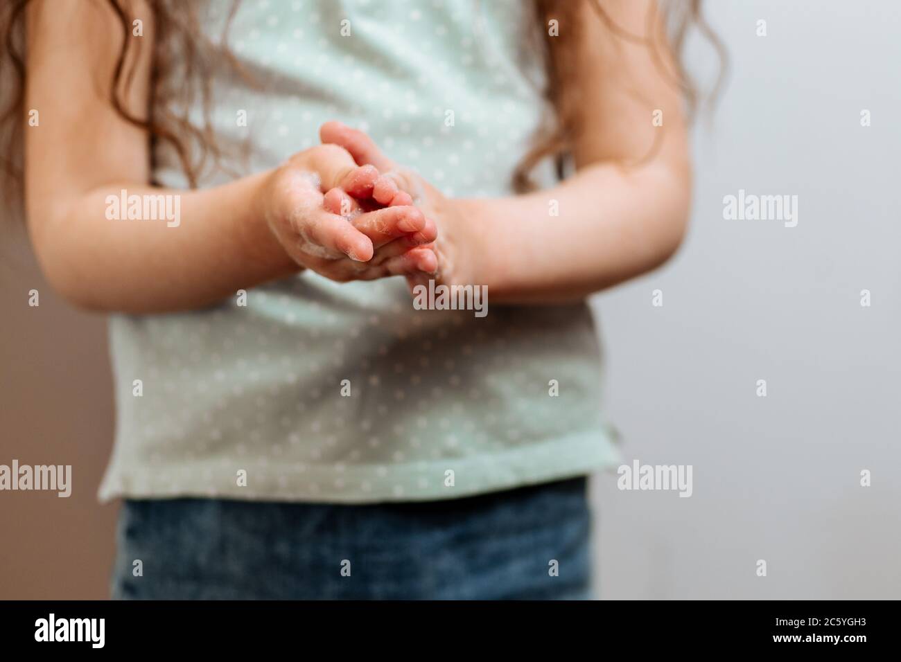 Mains d'enfants dans de la mousse savonneuse. Prévention de l'infection et de la dissémination du coronavirus, quarantaine Banque D'Images