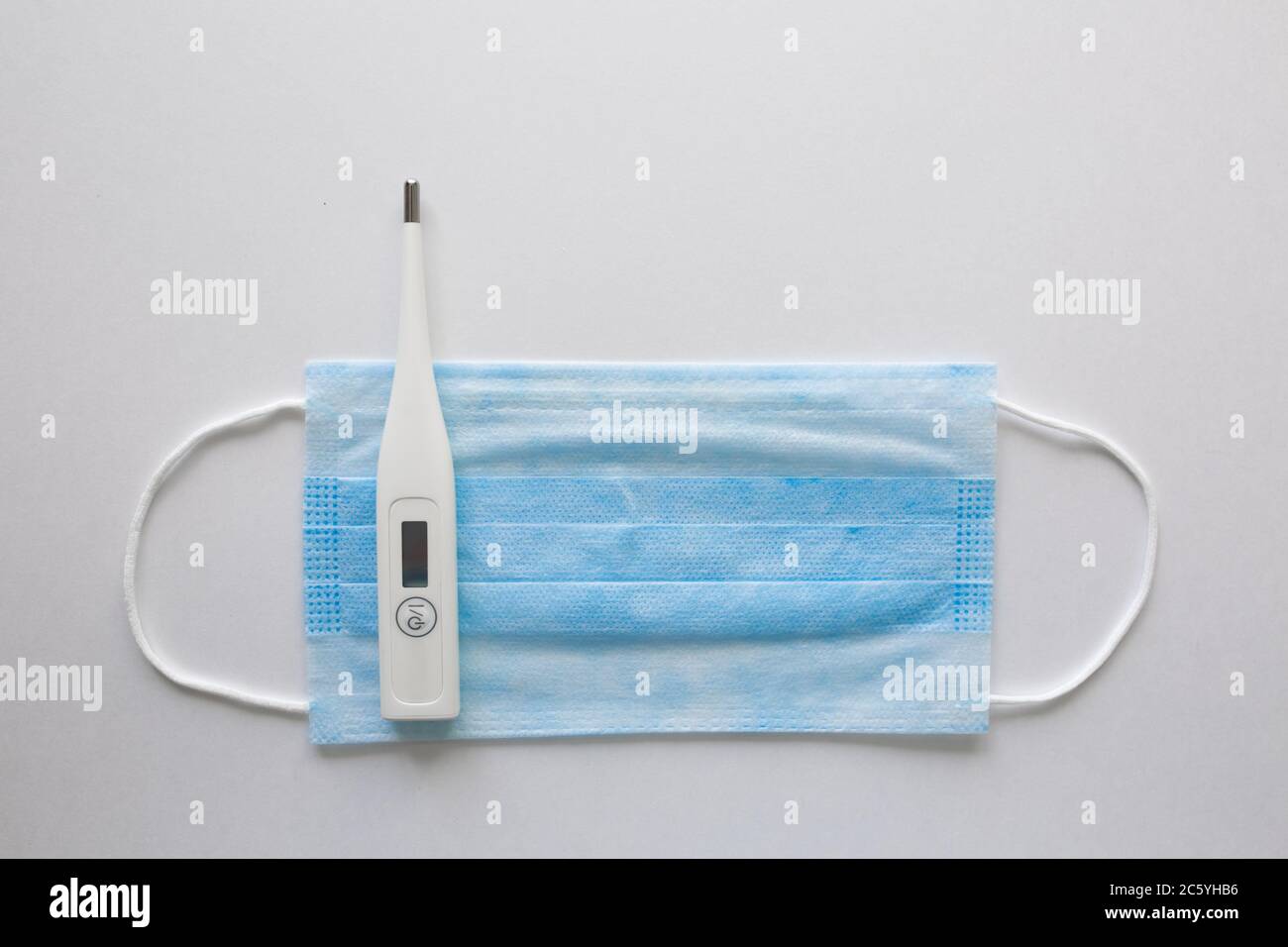 antécédents de coronavirus. Masque médical blanc et thermomètre sur masque blanc protection contre la pollution, le virus, la grippe et le coronavirus. Soins de santé et concept chirurgical. Banque D'Images