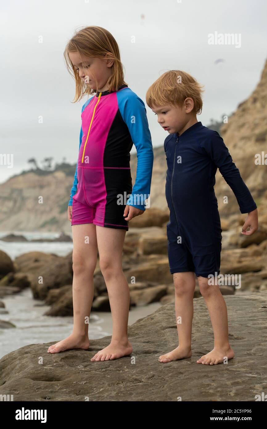Deux enfants, un jeune garçon et une fille, jouant sur une plage de sable Banque D'Images
