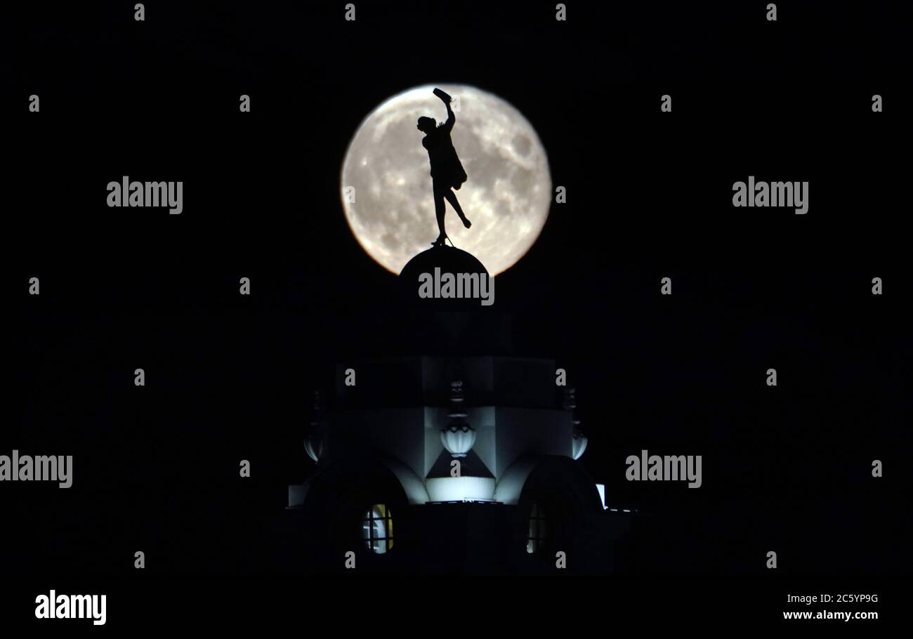 La pleine lune (connue sous le nom de lune en buck) s'élève sur une dame dansante dans le bâtiment de la ville espagnole à Whitley Bay. Banque D'Images