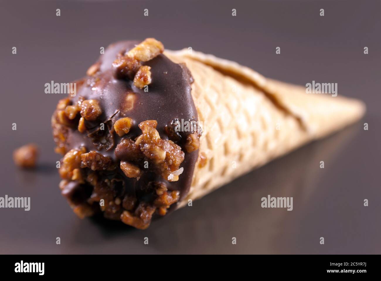 Rouleau de cachets à la crème, au chocolat et aux noix sur une assiette brune. Gros plan Banque D'Images