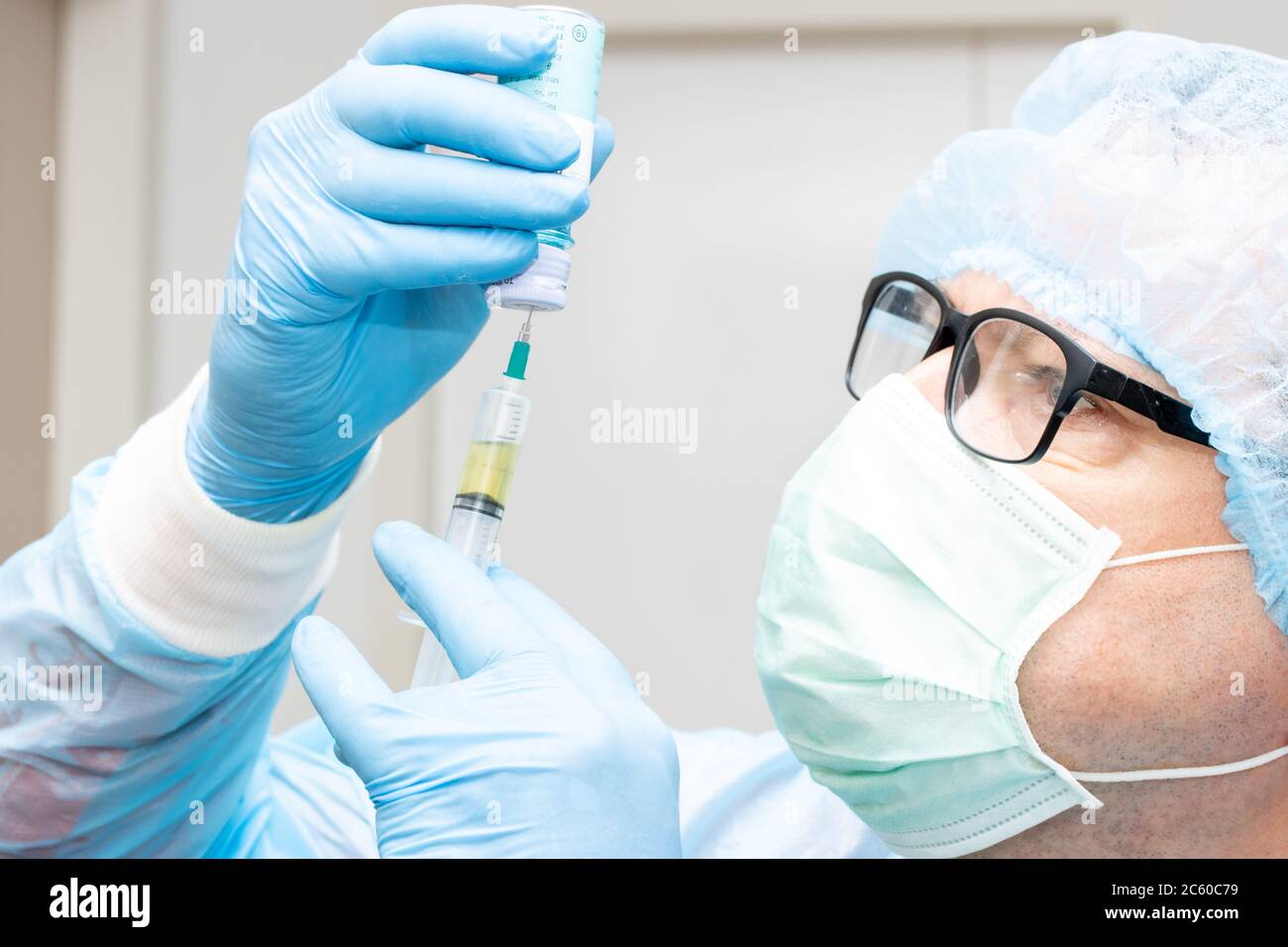 Le portrait du médecin prend le médicament d'une bouteille à une injection. Scientifique tenant la seringue et le vaccin, gros plan. Banque D'Images