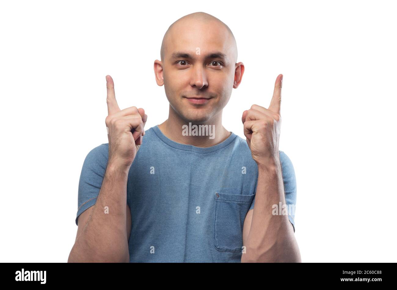 Photo d'un jeune bald pointant vers le haut homme dans un t-shirt bleu Banque D'Images