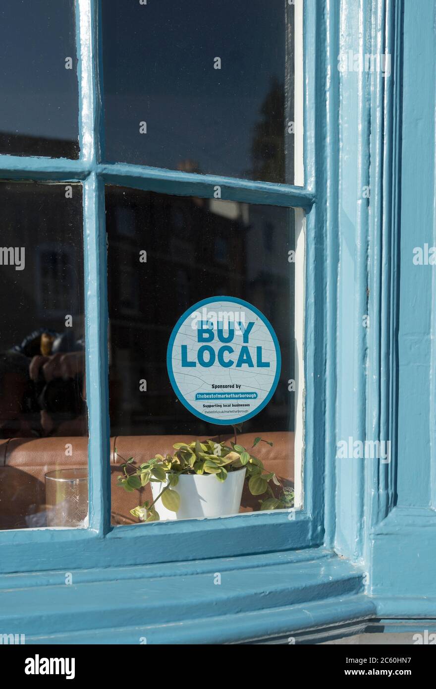 Autocollant dans une fenêtre encourageant les gens à acheter dans les magasins locaux au Royaume-Uni. Banque D'Images