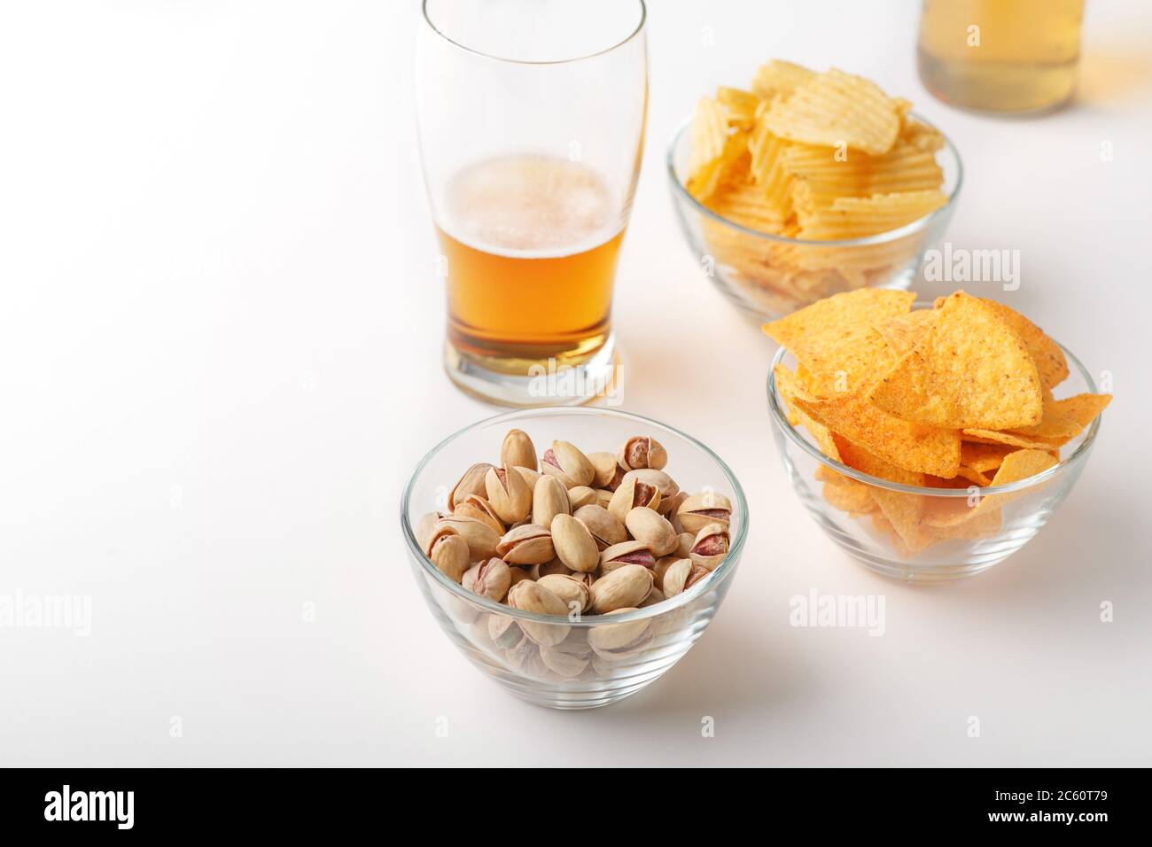 En-cas de bière. Lager brillant en verre, pistaches, nachos et chips Banque D'Images