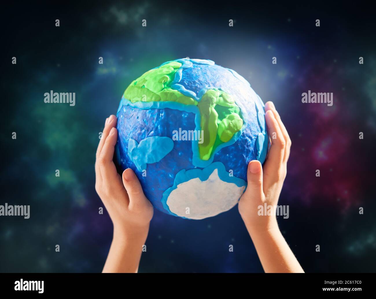 Enfant tenant la planète entre les mains contre l'arrière-plan de l'espace. Concept de vacances jour de la terre. Banque D'Images