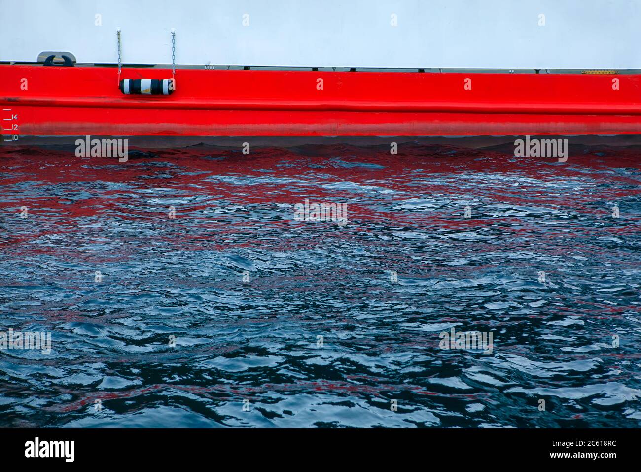 partie de la coque du navire qui est submergée dans l'eau . Panneau de ferry peint en rouge Banque D'Images