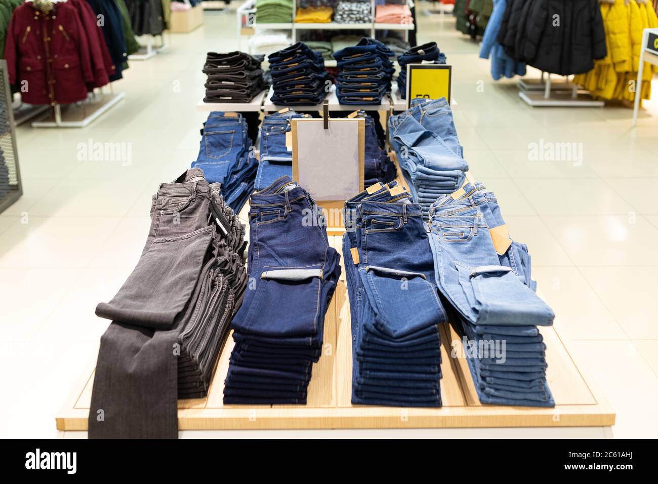 magasin de vêtements avec un grand assortiment de pantalons et de jeans  accrochés sur le cintre Photo Stock - Alamy