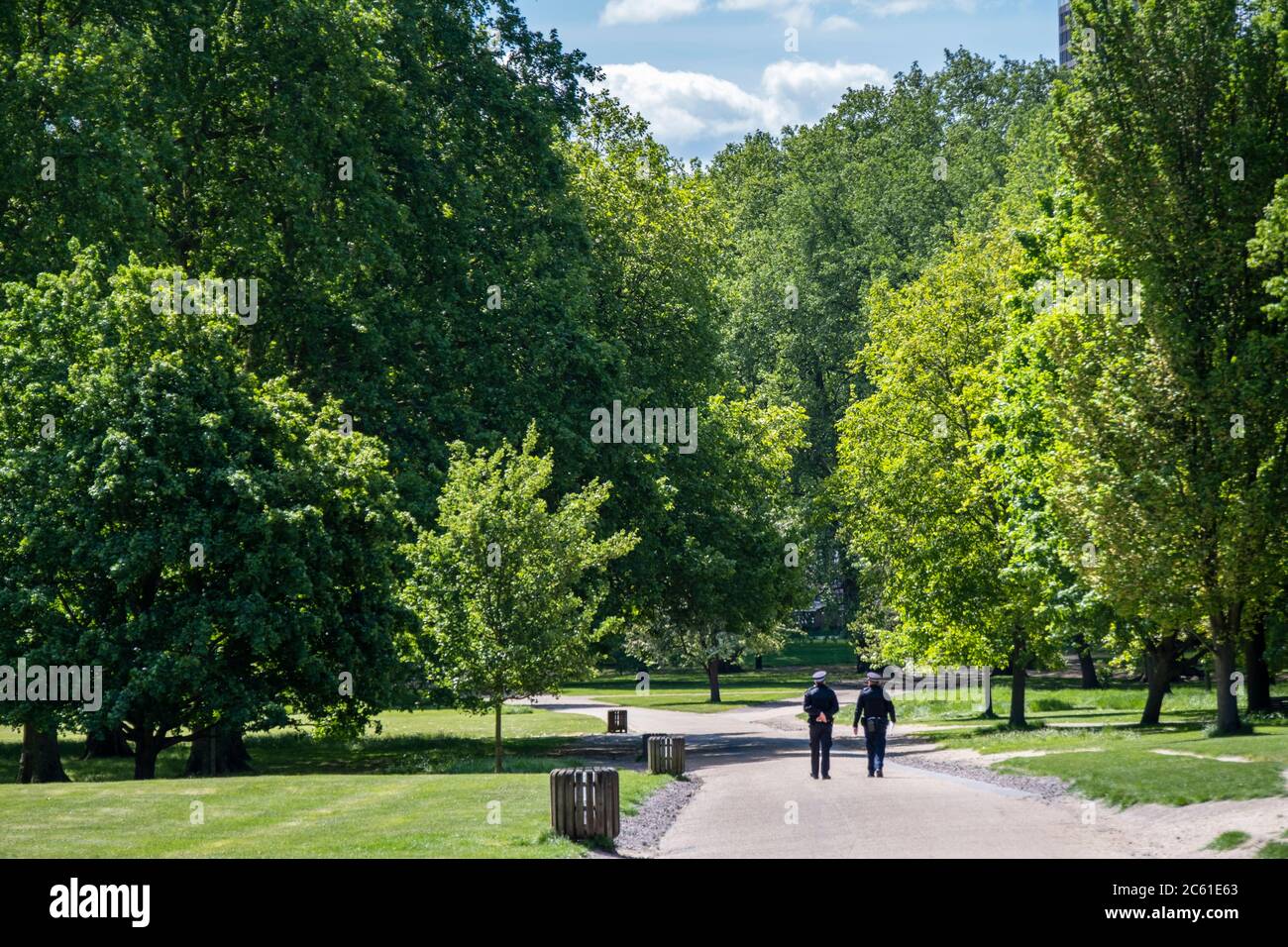 Royaume-Uni, Angleterre, Londres, Westminster, Green Park. Deux gendarmes de la police marchant sur un chemin à travers un parc vert vide, à côté du palais de Buckingham Banque D'Images
