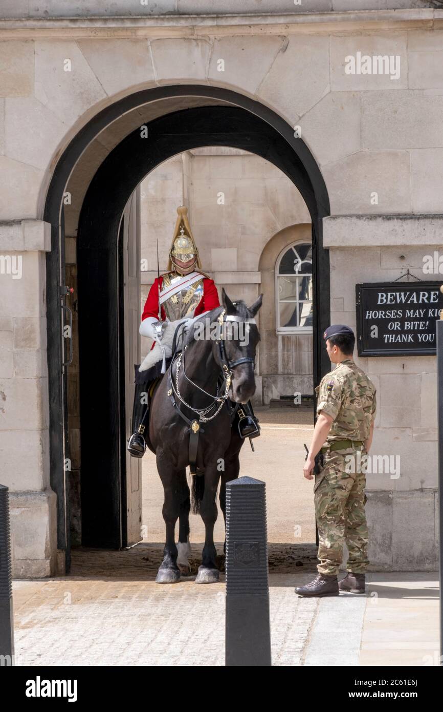Royaume-Uni, Londres, Horse Guards. Soldat de la Garde du cheval de la Reine, régiments de gardes de vie en uniforme moderne avec un collègue monté en robe cérémonielle Banque D'Images