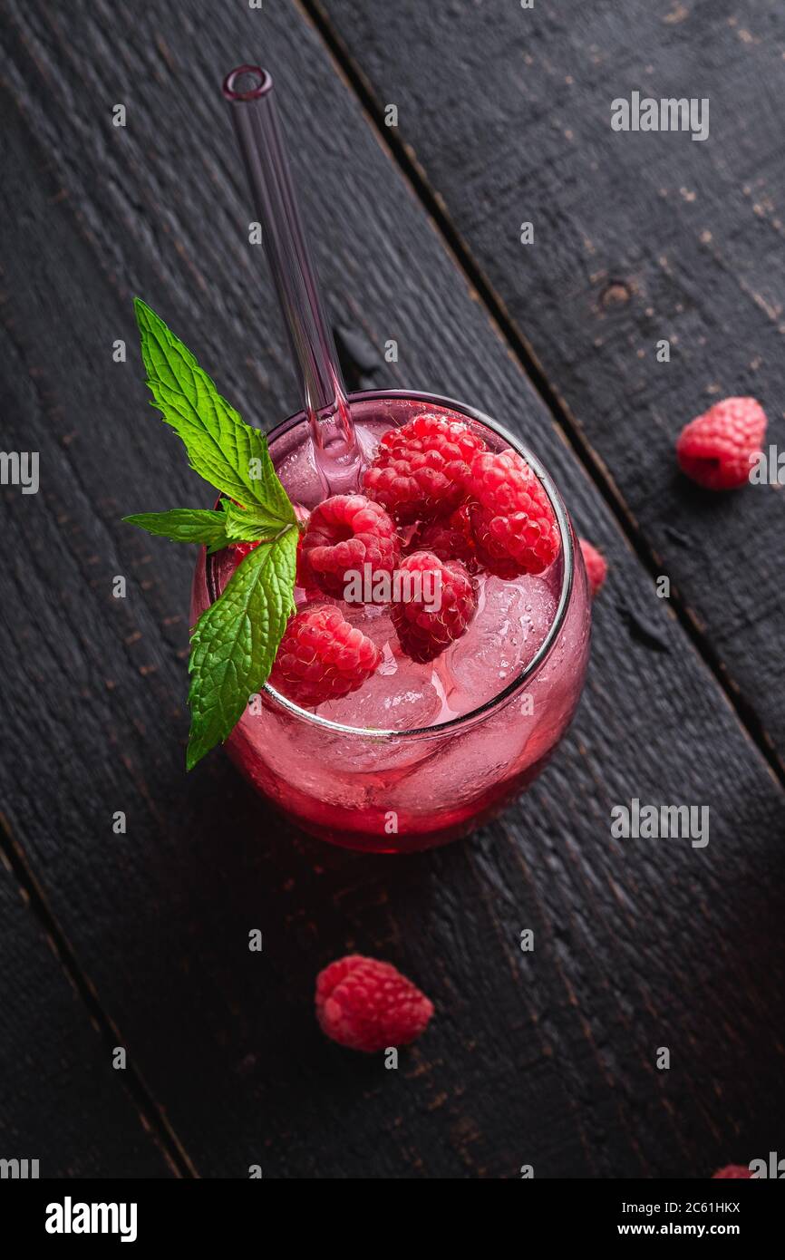 Glace fraîche boisson froide jus de baies à la menthe, limonade d'été à la framboise en verre avec pailles sur fond de bois foncé, vue en angle Banque D'Images