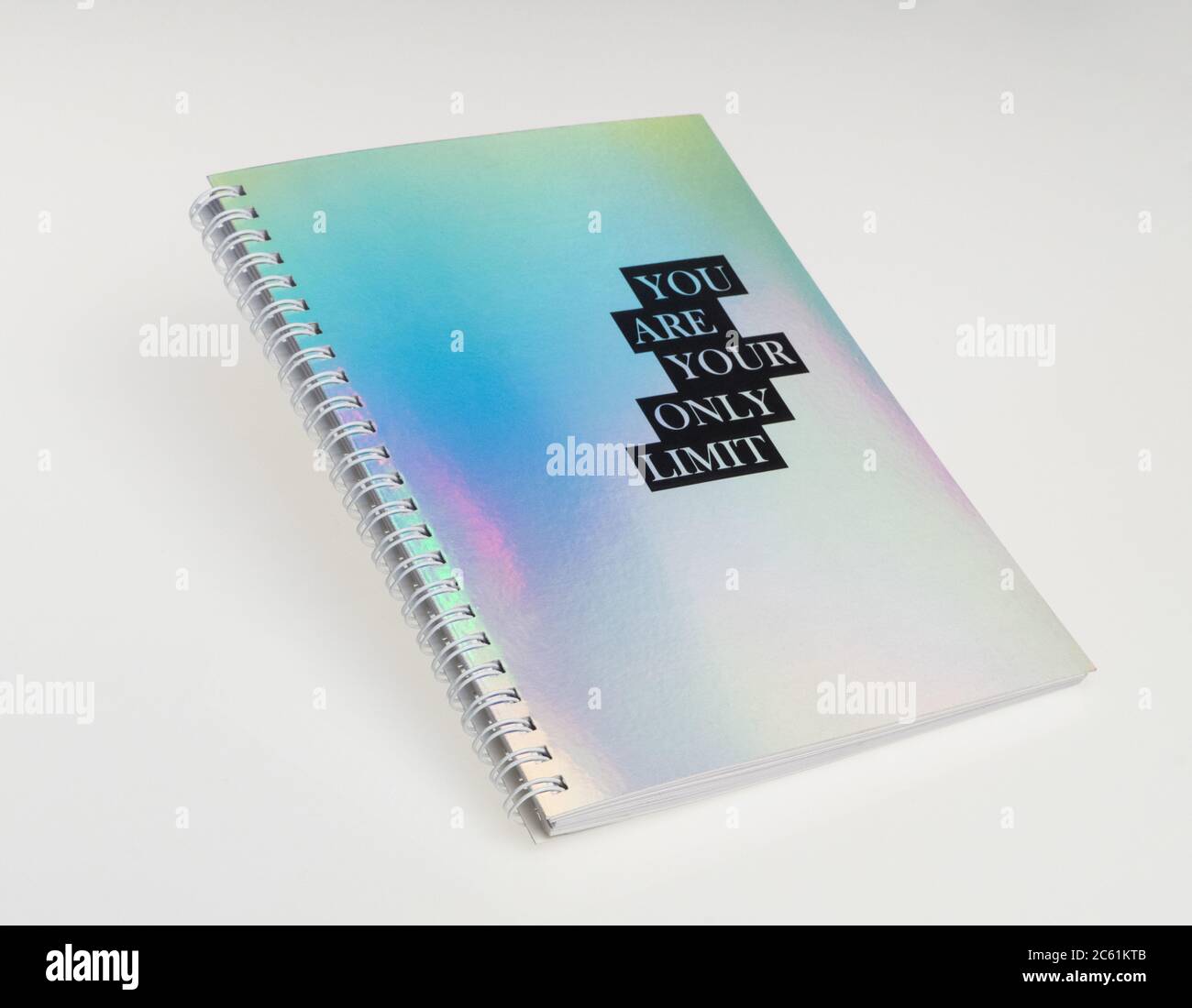 un carnet avec une couverture irisée et un texte motivationnel, sur fond blanc Banque D'Images