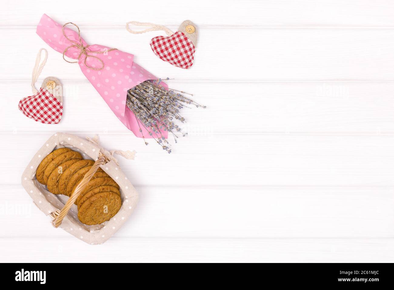 Bouquet de fleurs de lavande avec biscuits dans un panier sur table en bois blanc. Vue de dessus, espace de copie. Arrière-plan rustique Banque D'Images