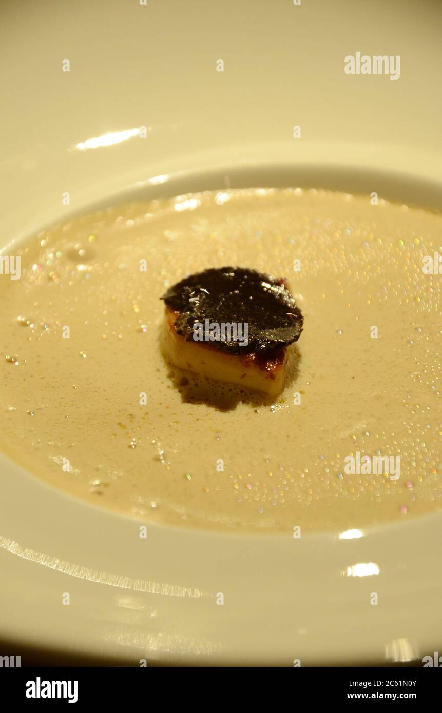 Foie gras de canard à la truffe sur une soupe crémeuse aux champignons. Le foie gras est une spécialité populaire et bien connue de la cuisine française. Banque D'Images