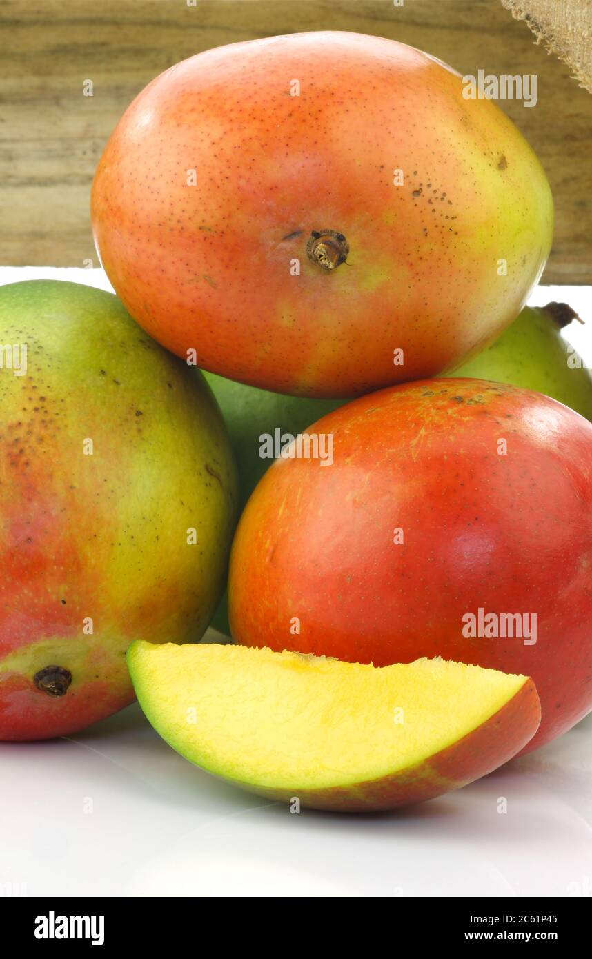 fruits frais de mangue dans une boîte en bois sur fond blanc Banque D'Images
