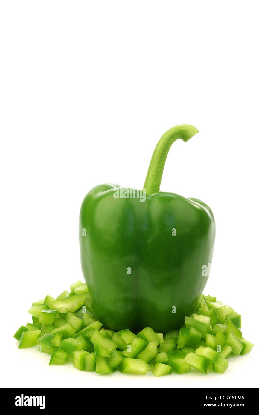 poivron vert frais (capsicum) avec face avant ouverte et morceaux de paprika déjà coupés sortant sur un fond blanc Banque D'Images