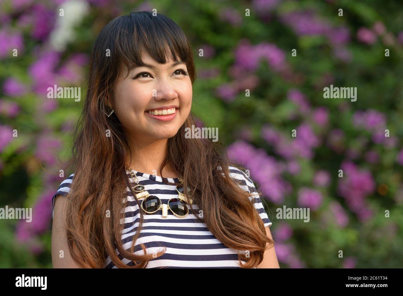 Bonne jeune femme asiatique belle pensant au parc Banque D'Images