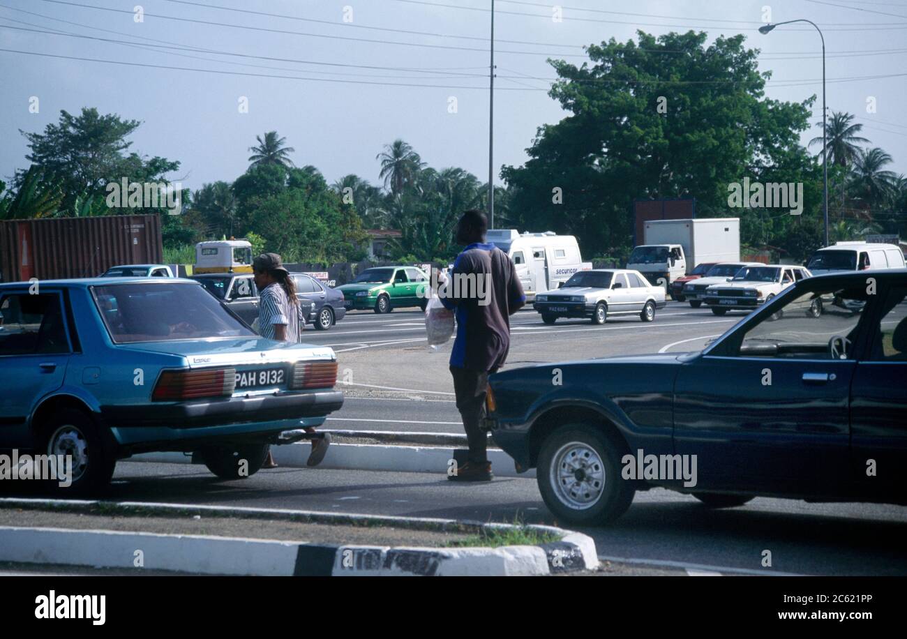 Port d'Espagne hommes marchant parmi la circulation Banque D'Images