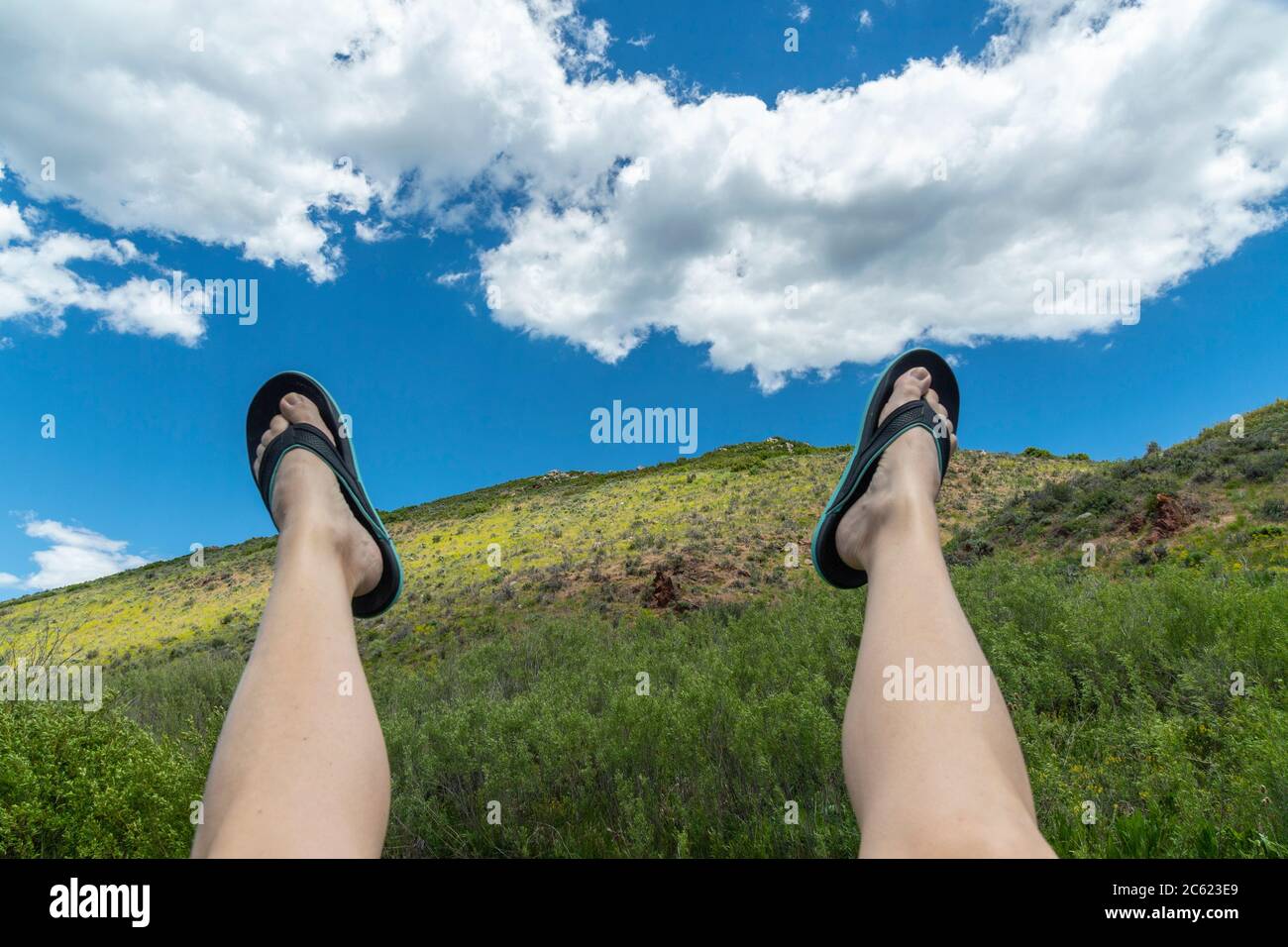 Une femme en jeu tient ses jambes dans l'air Banque D'Images