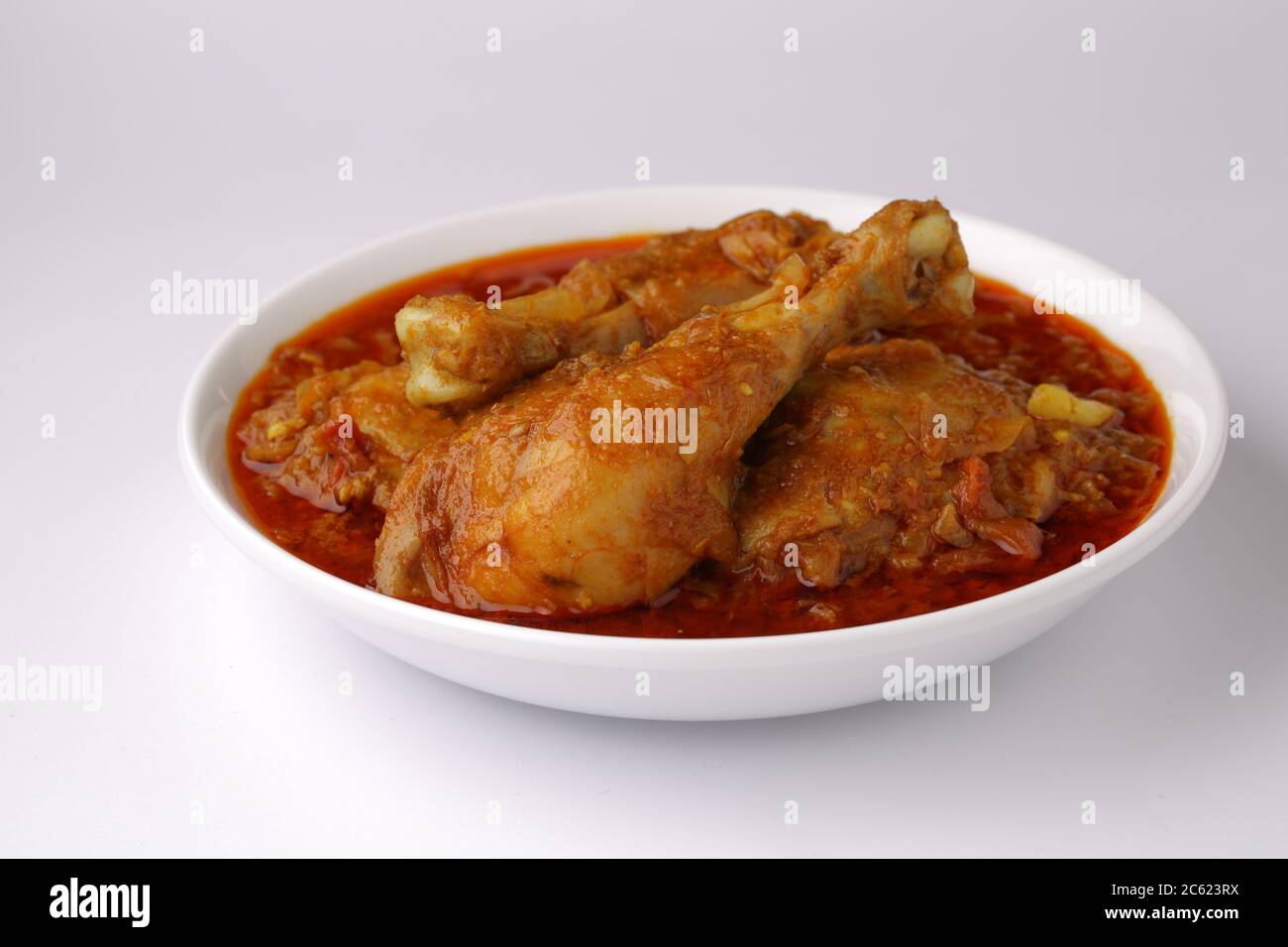 Curry de poulet ou masala, cari épicé de poulet masala fait à l'aide d'épices, oignon et ail dans le style indien du nord dans un bol en céramique blanche Banque D'Images