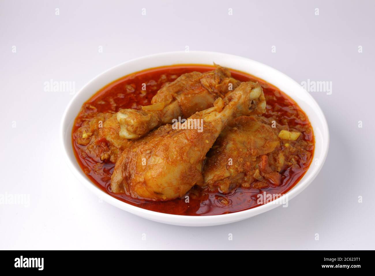 Curry de poulet ou masala, cari épicé de poulet masala fait à l'aide d'épices, oignon et ail dans le style indien du nord dans un bol en céramique blanche Banque D'Images