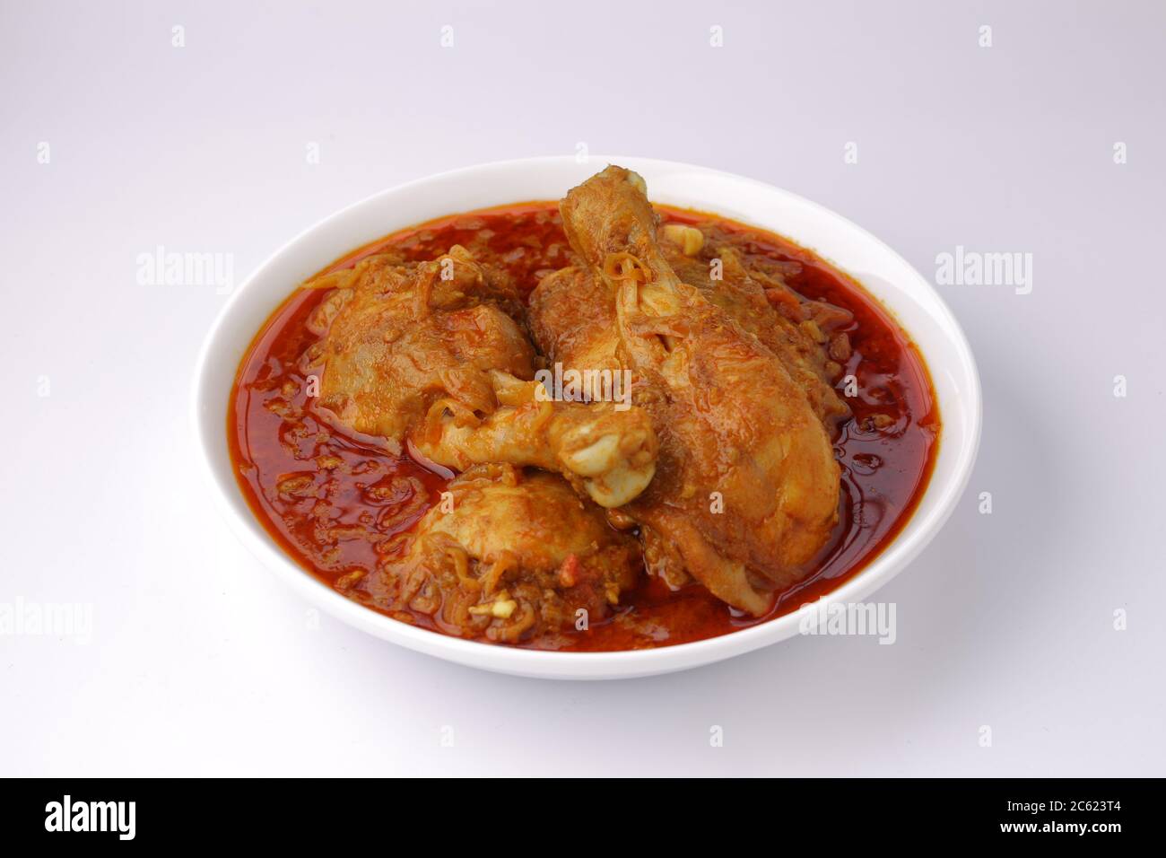 Curry de poulet ou masala, cari épicé de poulet masala fait à l'aide d'épices, oignon et ail dans le style indien du nord dans un bol en céramique blanche Banque D'Images